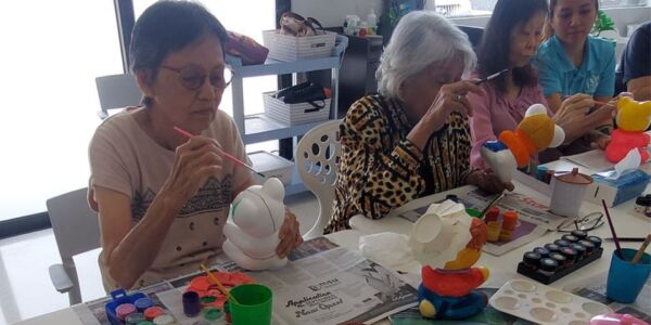 The elderly painting their own teddy bear as part of an activity